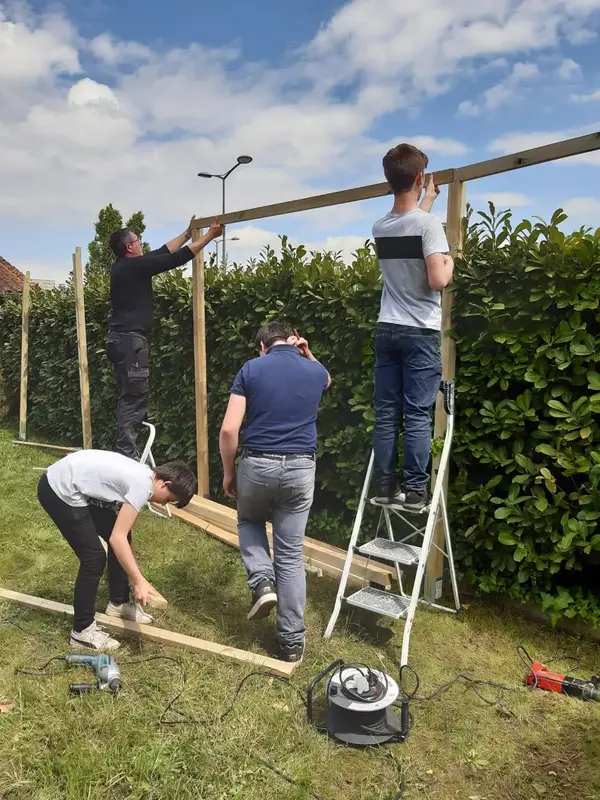 Groupe de bénévoles construisant une palissade en bois