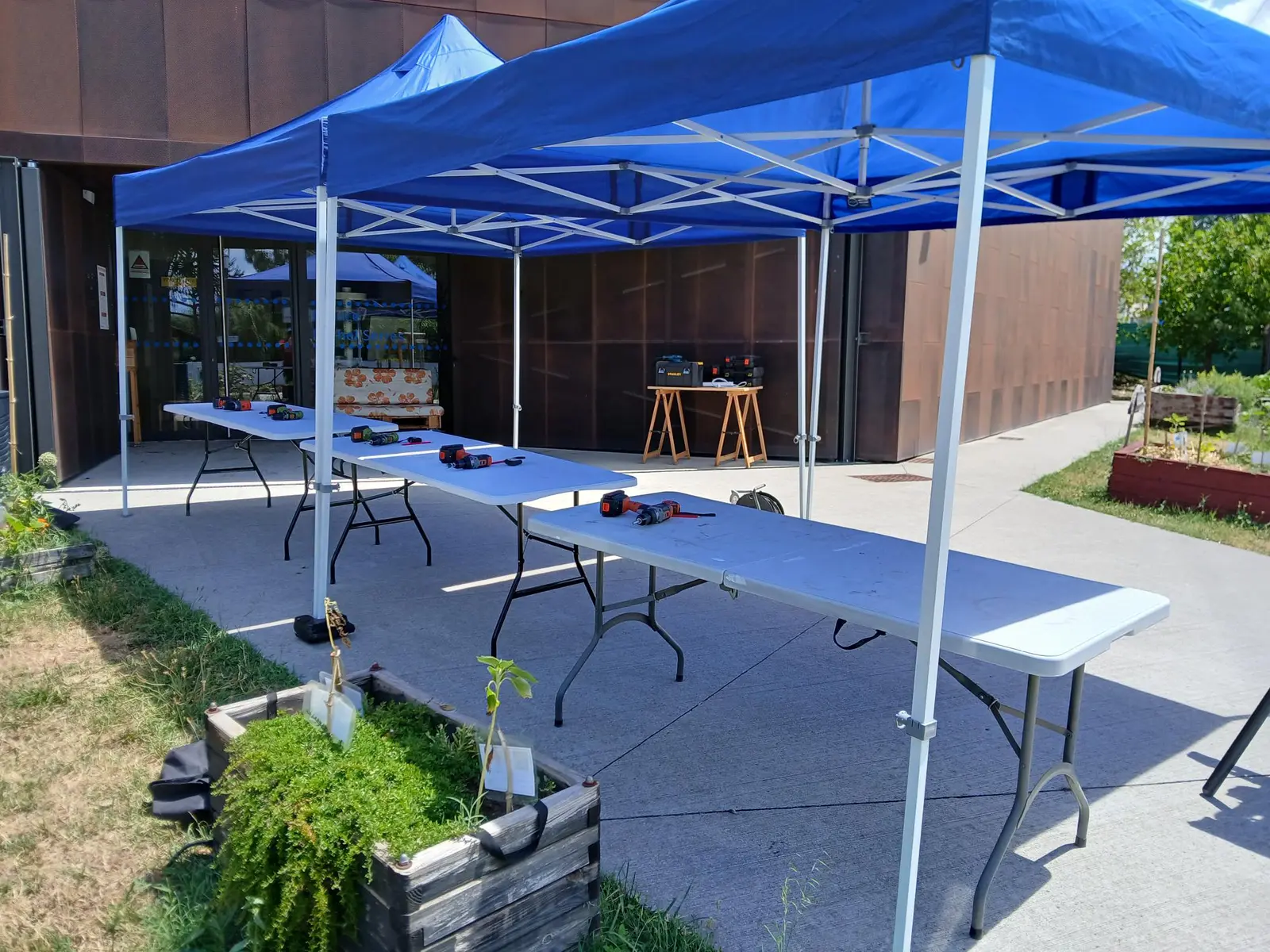 Tentes et tables installées pour un chantier participatif bois
